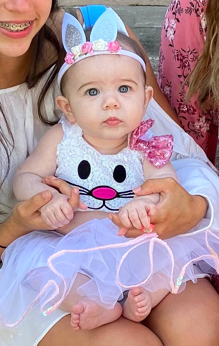 Gia is registered to the contest to win money with this photo: baby, baby_toddler_clothing, blurred, cap, cheek, child, event, finger, fun, happy, hat, headwear, human, jewellery, lip, magenta, person, pink, skin, sun_hat