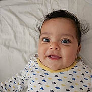 Zeyd participe au concours pour gagner de l'argent avec cette photo : baby, smiling, infant, face, cute, onesie, patterned_clothing, bed, white_bedspread, happy, child, lying_down, indoor, portrait, closeup, young_child, person, expression, joyful, adorable