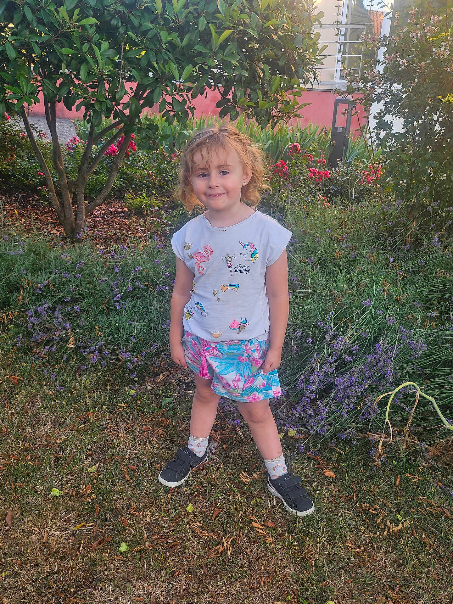 Tessa participe au concours pour gagner de l'argent avec cette photo : child, smiling, garden, flowers, greenery, tree, grass, shirt, skirt, socks, shoes, unicorn, flamingo, outdoor, nature, plants, daylight, person, happy, cute