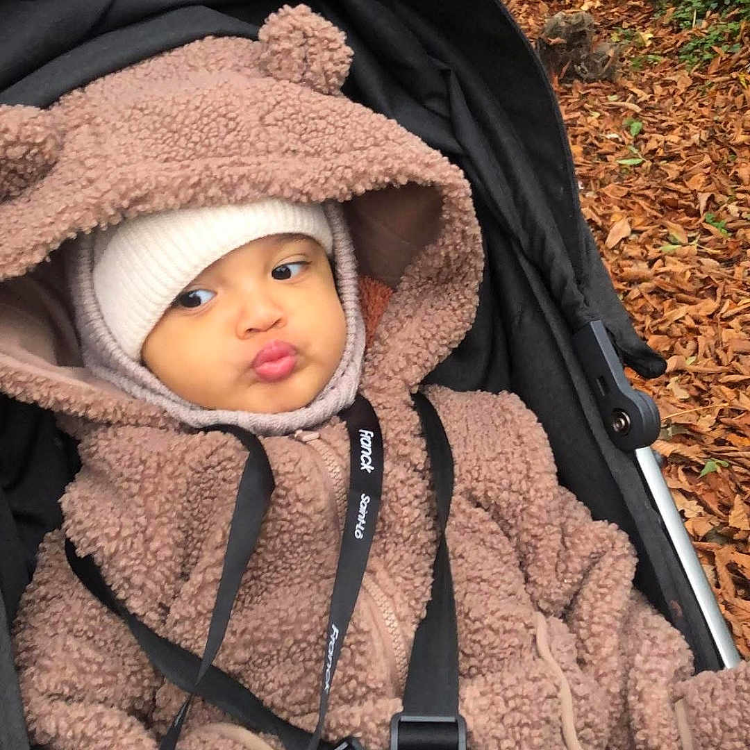 Soan a rejoint le concours — aidez-le/la à gagner de superbes lots ! autumn, baby, babywear, bundle, child, cold_weather, cute, expression, face, funny_face, hood, leaves, nature, outdoor, pacifier, park, pout, seatbelt, stroller, warm_clothing