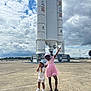 adventure, child, children, clouds, concrete, daylight, fun, happy, hat, outdoor, paper_airplane, pink_dress, playful, posing, rocket, shoes, shorts, sky, space, tarmac
