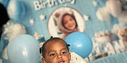 Soan participe au concours pour gagner de l'argent avec cette photo : background, balloons, birthday, blue, bracelet, celebration, child, clothing, cute, decorations, event, face, happy, high_chair, indoor, party, person, portrait, smile, toddler