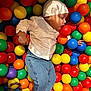baby, ball_pit, balls, blue_jeans, casual_clothing, child, colorful, cute, fun, indoor, infant, multicolor, playful, portrait, recreation, resting, socks, soft_lighting, white_hat, white_shirt