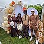adults, balloon_arch, balloons, casual_clothing, celebration, children, decorations, diverse, event, family, friends, grass, group, happy, nature, outdoor, party, people, portrait, smiling