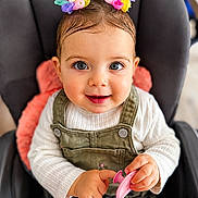 Giorgia participe au concours pour gagner de l'argent avec cette photo : baby, child, face, blue_eyes, hair_accessories, smiling, car_seat, toy, hands, clothing, overalls, white_sweater, cute, infant, portrait, indoor, happy, skin, expression, seatbelt