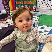 Freya joined the competition — help win amazing prizes! toddler, child, indoor, playroom, colorful, rainbow, cushion, toy, clothing, person, face, eyes, hair, expression, floor, banner, text, green, yellow, pattern