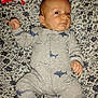 Timothy joined the competition — help win amazing prizes! baby, infant, onesie, shark_pattern, bedspread, floral_pattern, lying_down, red_eye, hand, face, sleepwear, child, cute, patterned_clothing, fabric, comfort, indoors, skin, head, expression