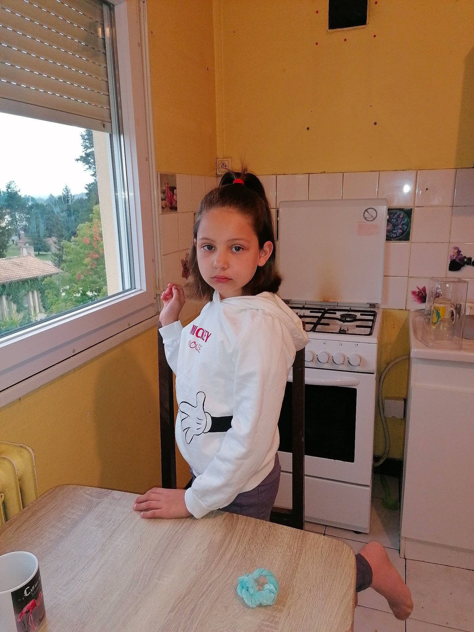 Shanone participe au concours pour gagner de l'argent avec cette photo : baby_toddler_clothing, cabinetry, chair, desk, door, floor, flooring, hardwood, house, kitchen, kitchen_appliance, person, refrigerator, room, sleeve, table, tableware, toddler, uniform, window