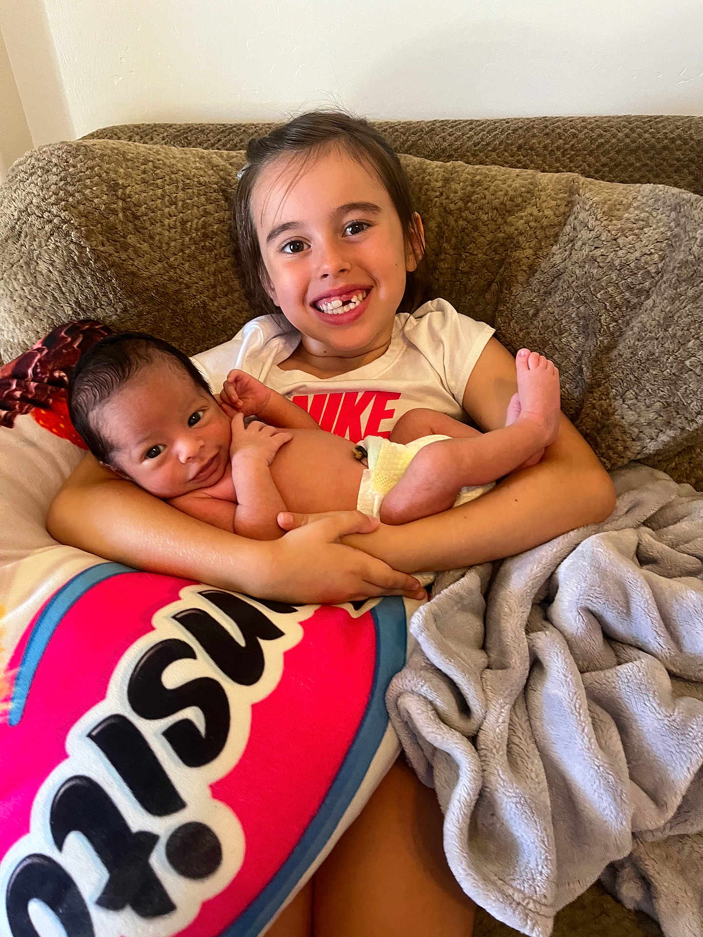 Cody Ryan is registered to the contest to win money with this photo: child, baby, smile, couch, blanket, pillow, infant, holding, family, indoors, relaxing, happy, young, sibling, comfort, clothing, toddler, cute, portrait, home