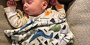 Quinn is registered to the contest to win money with this photo: baby, sleeping, blanket, dinosaur_pattern, plush_toy, couch, cozy, child, pacifier, cute, infant, rest, soft_toy, fabric, comfort, relaxation, indoor, clothing, head, peaceful