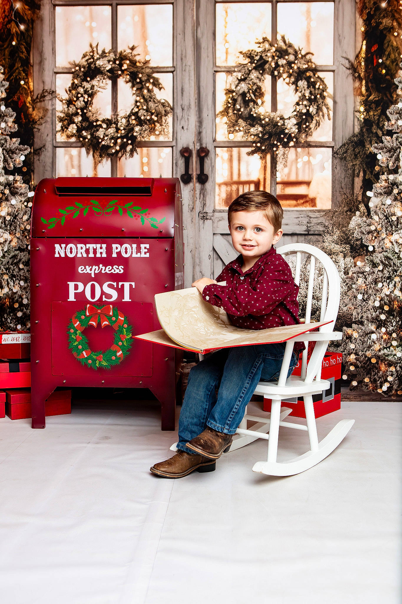 Branson is registered to the contest to win money with this photo: chair, child, event, flooring, flowerpot, holiday, joy, leisure, ornament, person, red, room, shoe, sitting, toddler, tree, window, winter, wood