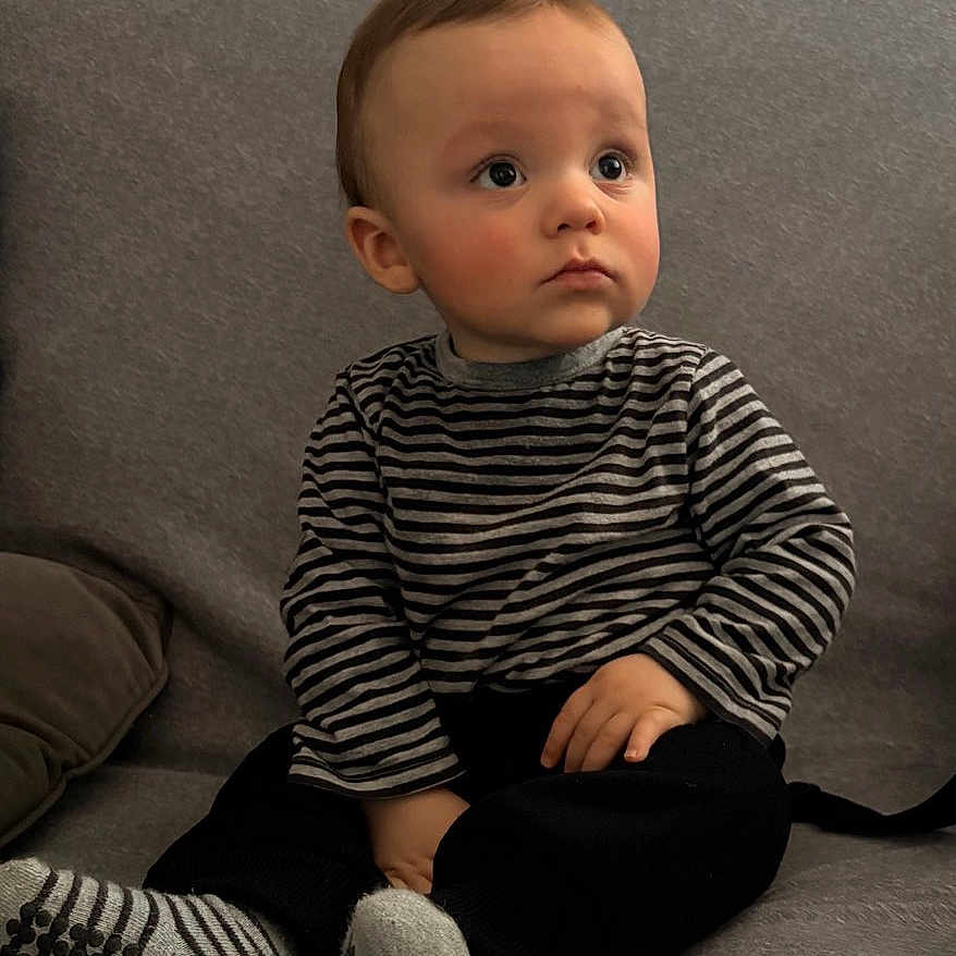 Kaylon a rejoint le concours — aidez-le/la à gagner de superbes lots ! casual, child, clothing, couch, cozy, cute, expression, face, feet, gray, hands, home, indoors, looking_away, portrait, sitting, socks, striped_shirt, toddler, young_child