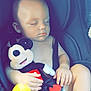 baby, sleeping, car_seat, plush_toy, mickey_mouse, child, infant, seatbelt, toy, cute, peaceful, resting, small_child, hand, face, legs, comfort, indoor, nap, child_safety