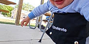 Lucian is registered to the contest to win money with this photo: baby, blue_onesie, child, clothing, concrete_floor, covered_patio, cute, daylight, fun, happy, harness, infant, outdoor, person, picnic_table, playful, safety, smiling, straps, young
