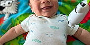 Lucian joined the competition — help win amazing prizes! baby, bright, child, closeup, colorful, cute, face, fun, happy, indoors, infant, lying_down, onesie, person, play_mat, playtime, shark_pattern, small_child, smiling, toy