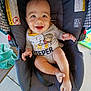 Lucian is registered to the contest to win money with this photo: baby, car_seat, casual, child, cute, expression, face, footwear, hands, happy, indoor, infant, legs, onesie, person, seat, smiling, striped_clothing, towel, toy