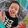 Lucian is registered to the contest to win money with this photo: baby, black_clothing, blanket, child, colorful, cute, face, happy, head, hippo, indoors, infant, person, play_mat, plush_toy, skeleton_print, smiling, toddler, tongue_out, young_child