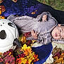 baby, child, costume, halloween, pumpkin, autumn_leaves, blanket, outdoor, face, cute, festive, holiday, seasonal, smiling, person, headwear, decoration, nature, grass, portrait