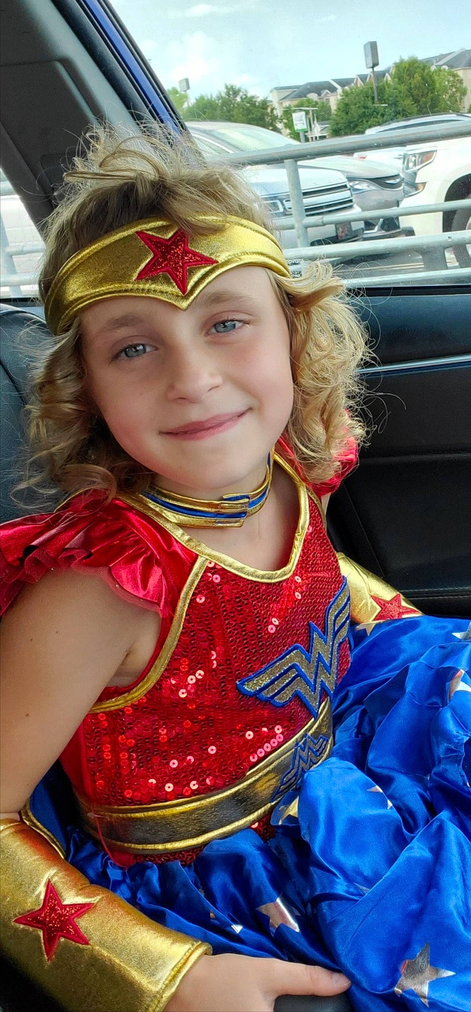 Annabelle is registered to the contest to win money with this photo: automotive_design, beauty, blond, child, chin, dress, earrings, electric_blue, event, face, fun, hairstyle, happy, headwear, jewellery, joy, light, motor_vehicle, neck, person