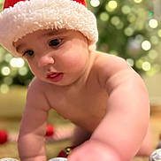 Alexander joined the competition — help win amazing prizes! baby, cheeks, child, christmas_hat, christmas_tree, closeup, crawling, curious, cute, decorations, face, festive, happy, holiday_ornaments, indoor, red, seasonal, skin, soft_focus, white