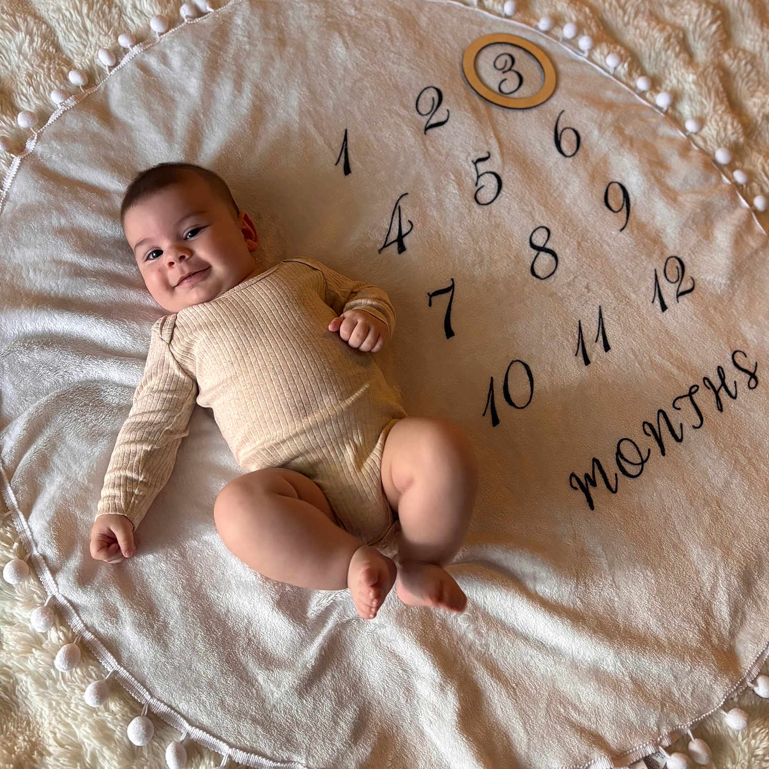 Maylonn a rejoint le concours — aidez-le/la à gagner de superbes lots ! baby, blanket, child, cozy, cute, face, floor, happy, indoor, infant, lying_down, months, number, onesie, pom_poms, portrait, skin, smiling, soft, wooden_frame