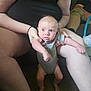 baby, infant, person, adult, cactus_onesie, blue_eyes, indoor, couch, carpet, sitting, holding, legs, arms, casual_clothing, relaxing, living_room, curious_expression, skin, hand, foot