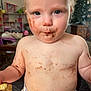 Rosey is registered to the contest to win money with this photo: baby, candid, child, chocolate, christmas_tree, closeup, cute, diaper, eating, face, food, indoor, infant, living_room, messy, person, skin, smiling, toddler, toy