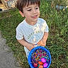 Shane is registered to the contest to win money with this photo: child, boy, easter_eggs, bucket, grass, sidewalk, outdoor, smile, tshirt, sandals, fence, garden, sunlight, colorful, holiday, spring, nature, play, young, happy