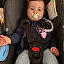 baby, pacifier, car_seat, child, infant, safety_harness, clothing, pink_bow, pacifier_clip, blue_jeans, face, hand, seat, straps, indoor, cute, child_seat, expression, person, young_child