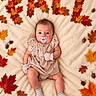 baby, infant, child, portrait, lying_down, pacifier, striped_socks, dress, blanket, autumn, fall_leaves, maple_leaves, oak_leaves, acorns, cozy, indoor, flat_lay, centered_composition, brown_hair, adorable