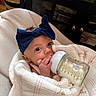 Gianna joined the competition — help win amazing prizes! baby, infant, bottle, milk, blanket, headband, blue_bow, hand, face, eyes, indoor, furniture, couch, person, cute, feeding, newborn, cozy, wrapped, portrait