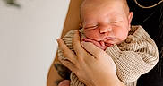 Blaze is registered to the contest to win money with this photo: newborn, baby, infant, person, hands, face, sleeping, knitted_clothing, cozy, smile, adult, holding, portrait, skin, peaceful, closeup, warmth, gentle, human, parent