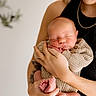 newborn, baby, infant, person, hands, face, sleeping, knitted_clothing, cozy, smile, adult, holding, portrait, skin, peaceful, closeup, warmth, gentle, human, parent