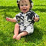 baby, child, grass, outdoor, smiling, happy, sitting, clothing, hood, sunlight, green, nature, cute, portrait, infant, one_person, grass_field, daylight, casual, young