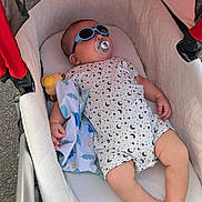 Massyl participe au concours pour gagner de l'argent avec cette photo : baby, child, stroller, sunglasses, pacifier, toy, blanket, onesie, patterned_clothing, infant, relaxing, outdoor, shade, cute, sleeping, hand, foot, face, head, comfort