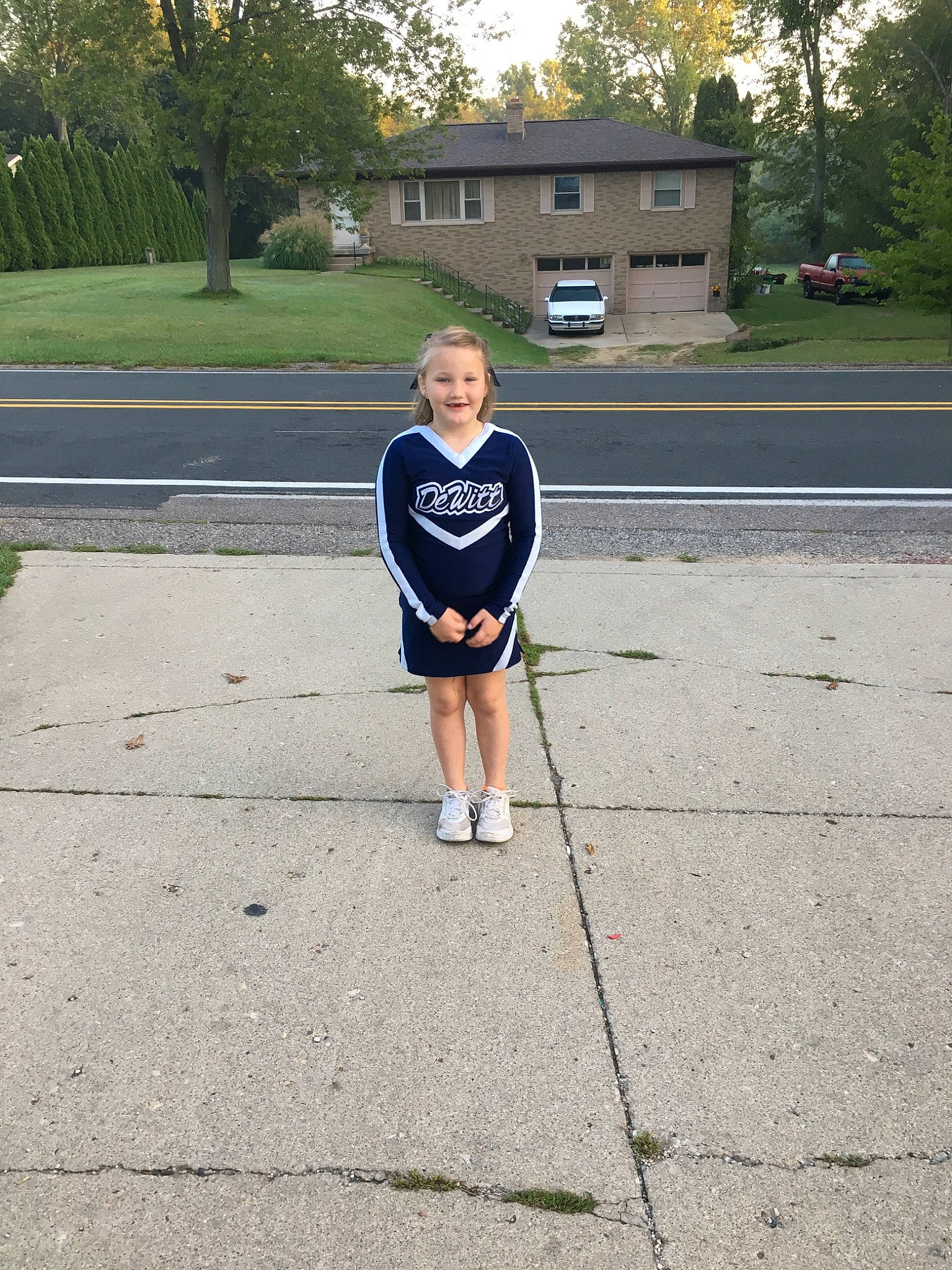 Morgan is registered to the contest to win money with this photo: asphalt, child, electric_blue, footwear, human_leg, joint, joy, knee, leisure, person, photography, plant, recreation, road, shoe, standing, summer, toddler, tree, vacation