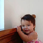 Hannia joined the competition — help win amazing prizes! toddler, child, smiling, dress, floral, wooden_furniture, indoor, happy, face, hair, person, baby, cute, standing, hand, skin, room, light, wall, home