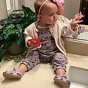 Maddison joined the competition — help win amazing prizes! toddler, child, pink_bow, headband, bathroom, mirror, plant, countertop, sink, reflection, clothing, sandals, floral_pattern, pensive, indoor, person, young_child, holding_object, casual, home