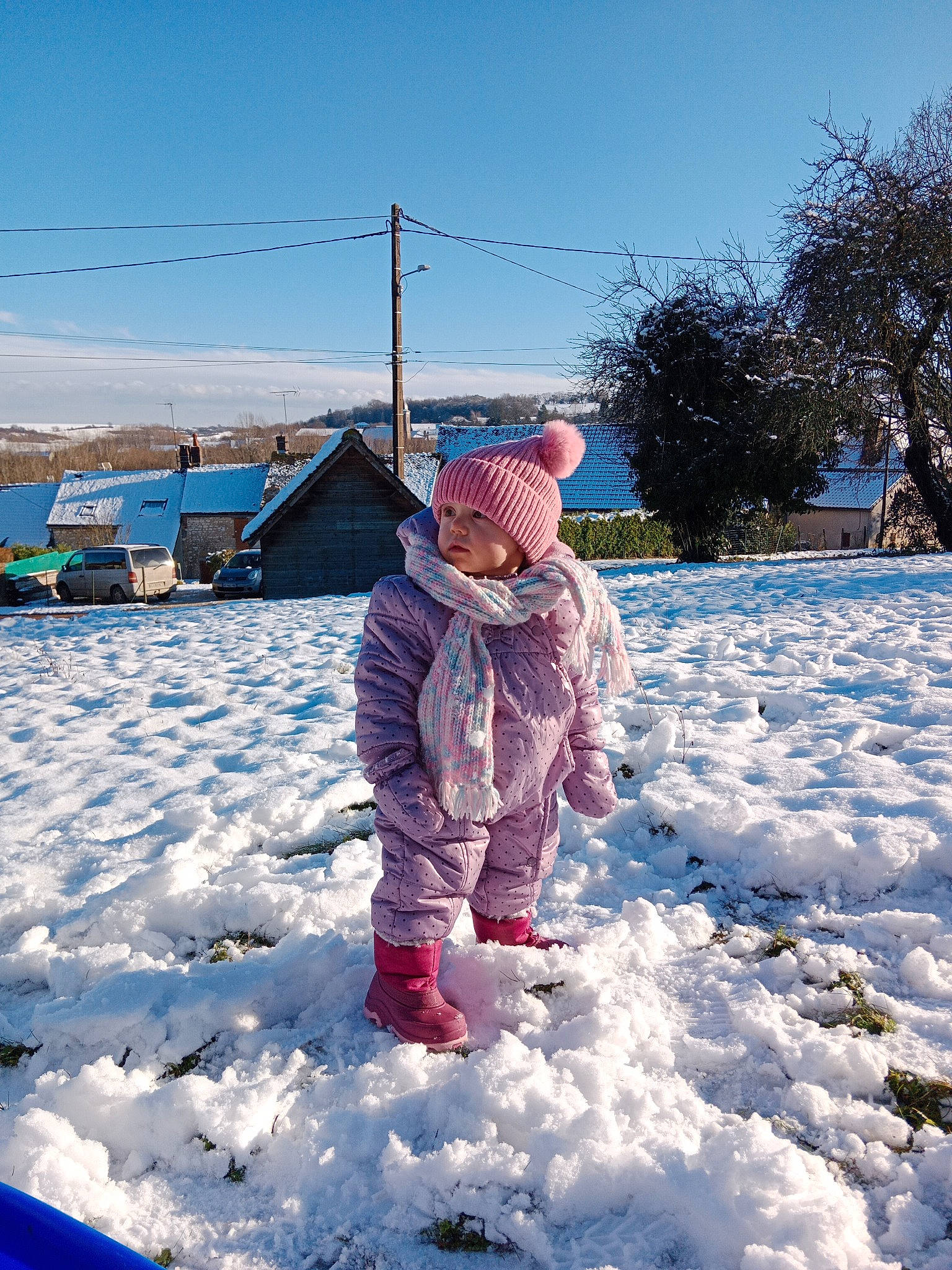 Pauline participe au concours pour gagner de l'argent avec cette photo : cloud, electric_blue, freezing, fun, geological_phenomenon, grass, headwear, house, ice_cap, jacket, landscape, leisure, people_in_nature, person, playing_with_kids, recreation, sky, slope, snow, toddler