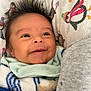 Greyson is registered to the contest to win money with this photo: baby, smile, hair, blanket, penguin_pattern, cozy, infant, face, child, cute, clothing, fabric, portrait, happy, warm, indoors, soft, head, eyes, person