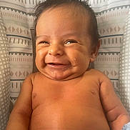 Greyson joined the competition — help win amazing prizes! baby, smiling, face, infant, bare_chest, blanket, patterned_background, happy, child, cute, skin, portrait, young, indoors, human, head, small_person, expression, sitting, cheerful