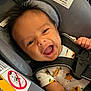 Greyson is registered to the contest to win money with this photo: baby, car_seat, infant, smiling, happy, onesie, orange_pattern, safety_harness, child, cute, seatbelt, infant_clothing, car_safety, young_child, face, portrait, indoor, human, baby_smile, closeup