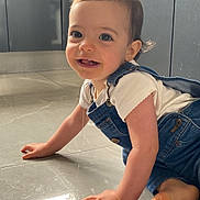 Isabella participe au concours pour gagner de l'argent avec cette photo : baby, child, toddler, crawling, denim_overalls, white_shirt, smiling, floor, tile_floor, indoor, kitchen, modern, reflection, cute, happy, person, face, hand, foot, light