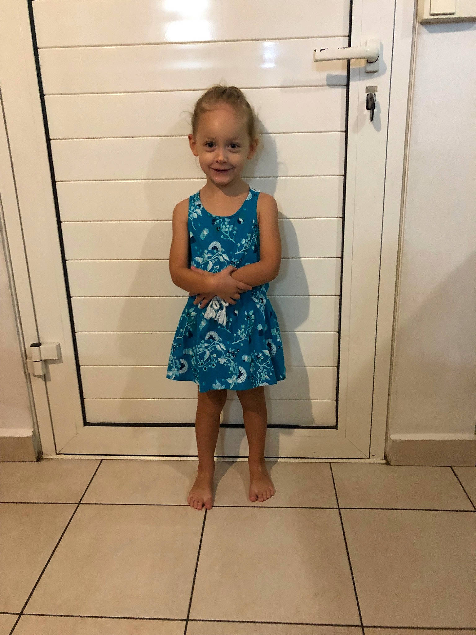 Cassandra a rejoint le concours — aidez-le/la à gagner de superbes lots ! barefoot, child, door, dress, floor, flooring, fun, joy, person, plumbing_fixture, room, standing, tile, toddler, vacation