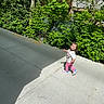 Clarette Amelia is registered to the contest to win money with this photo: balcony, bushes, casual, child, clothing, concrete, daylight, greenery, house, nature, outdoor, person, shadow, sidewalk, smiling, sneakers, sunlight, toddler, tree, walking