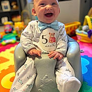 Landon is registered to the contest to win money with this photo: baby, infant, smiling, blue_bow_tie, onesie, baby_seat, play_mat, toys, indoor, child, happy, cute, sitting, colorful, portrait, young_child, soft_lighting, home, fun, cheerful