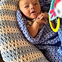 baby, blanket, crocheted, blue, white, infant, face, hands, toy, expression, cozy, smile, child, cute, wrapped, closeup, indoor, soft, warm, portrait