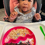 Cherish is registered to the contest to win money with this photo: toddler, child, high_chair, food, rice, meat, plate, spoon, drool, curious, eating, meal, clothing, baby, indoor, table, person, face, hand, expression