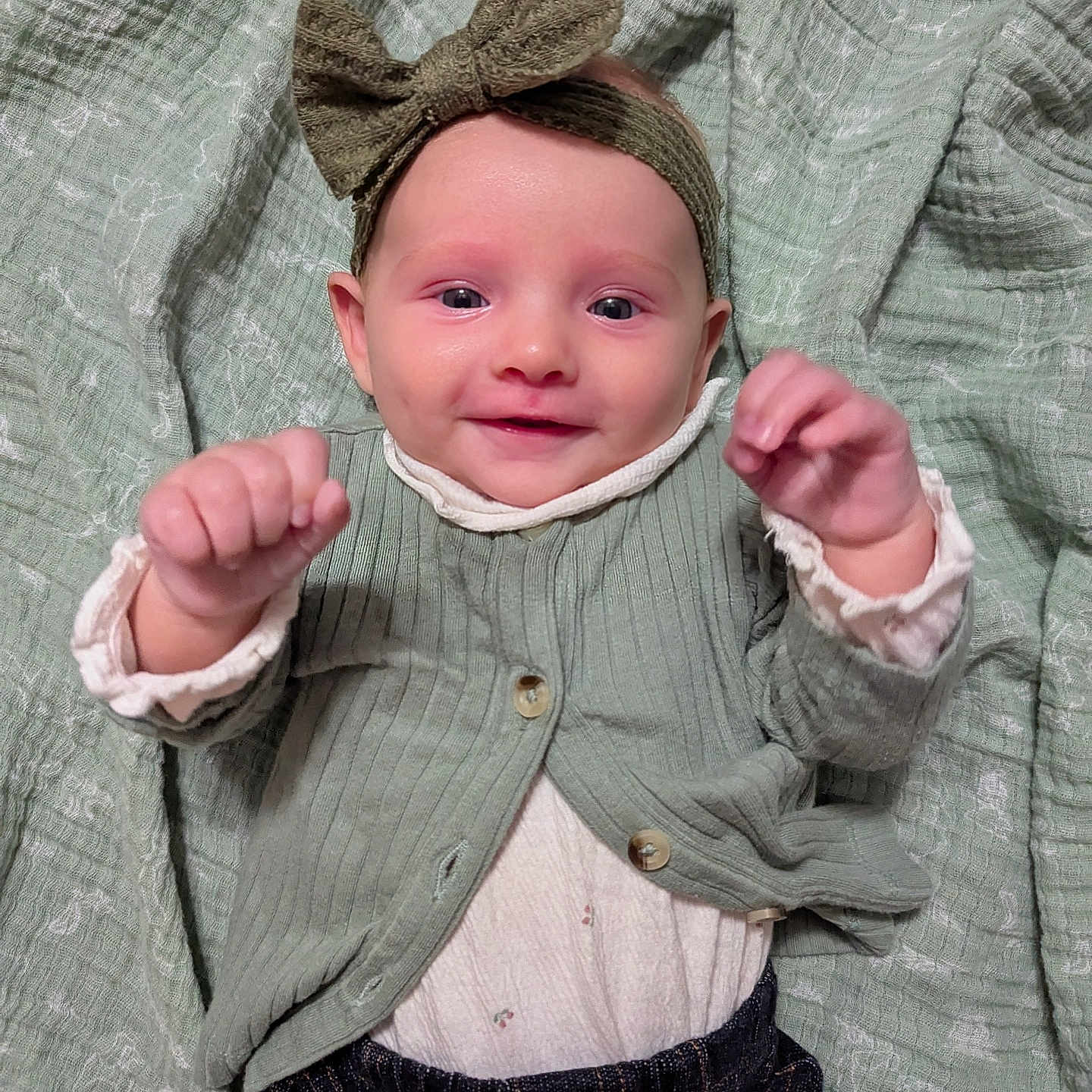 Blaney joined the competition — help win amazing prizes! baby, blanket, bow, cardigan, child, clothing, cute, fabric, face, happy, headband, indoor, infant, jeans, person, portrait, raised_hands, smiling, texture, toddler