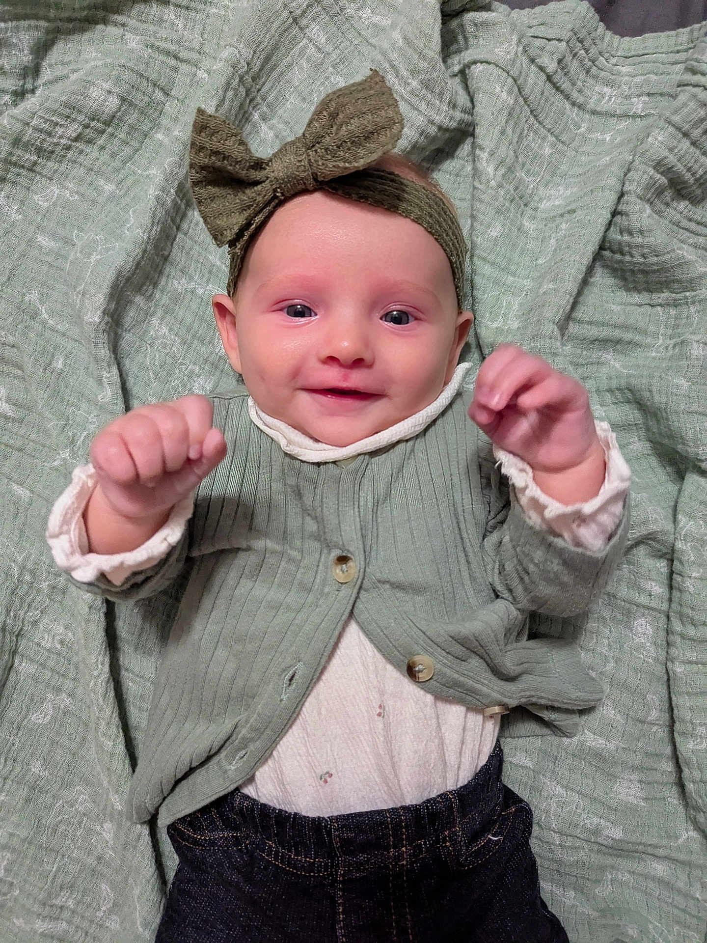 Blaney joined the competition — help win amazing prizes! baby, infant, headband, bow, cardigan, clothing, blanket, smiling, happy, raised_hands, cute, portrait, child, toddler, indoor, fabric, texture, face, person, jeans